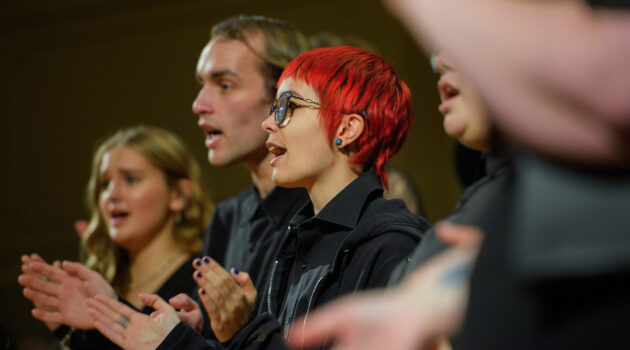 Group of choir members clapping and singing
