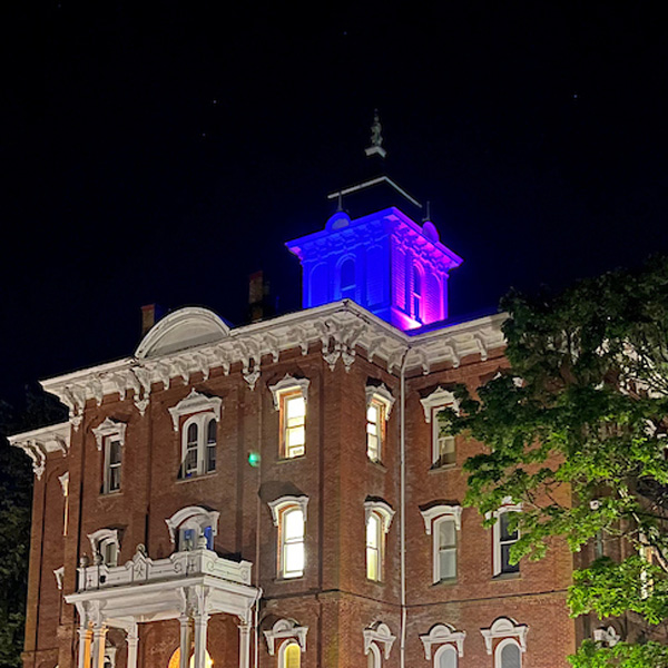 Pioneer Hall with cupola lit blue and pink for National Nurses Week.