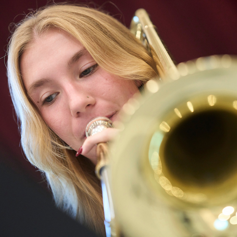 Blond woman plays a trombone