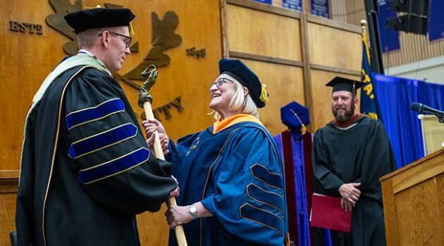 Mark Blegen receiving the ceremonial mace from Julie Fitzwater.
