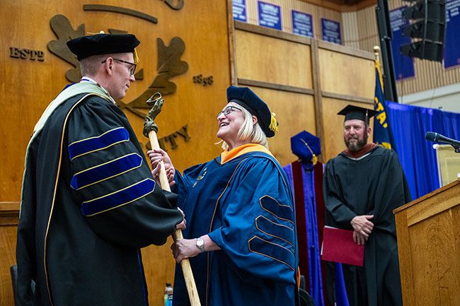 Mark Blegen receiving the ceremonial mace from Julie Fitzwater.