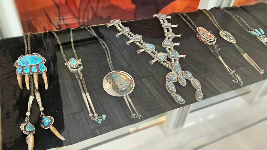 row of turquoise jewelry in a display case of the Pueblo Traditions, Indigenous art exhibition
