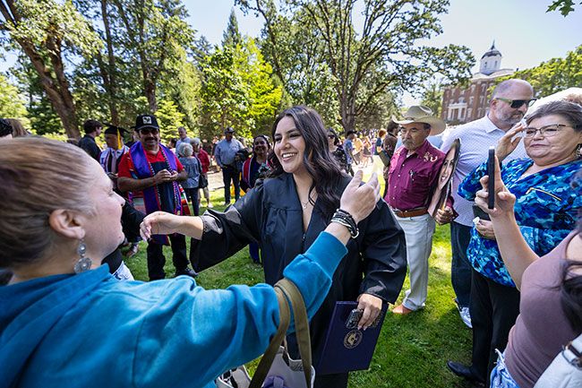 Student goes in to hug family members after commencement ceremony
