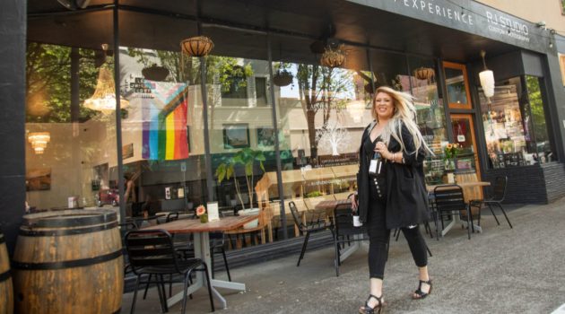Tiffany Morris walks outside Acorn to Oak Wine Experience on Third Street holding a wine bottle