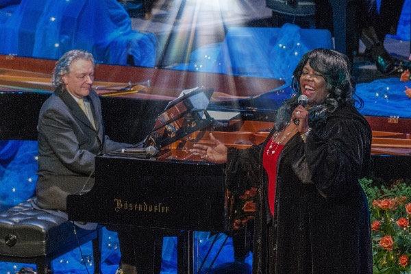 Michael Allen Harrison plays on the piano with Julianne Johnson singing in the foreground.