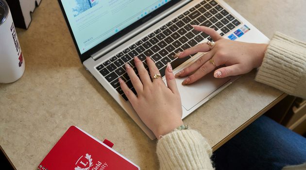 Close up on hands on laptop.