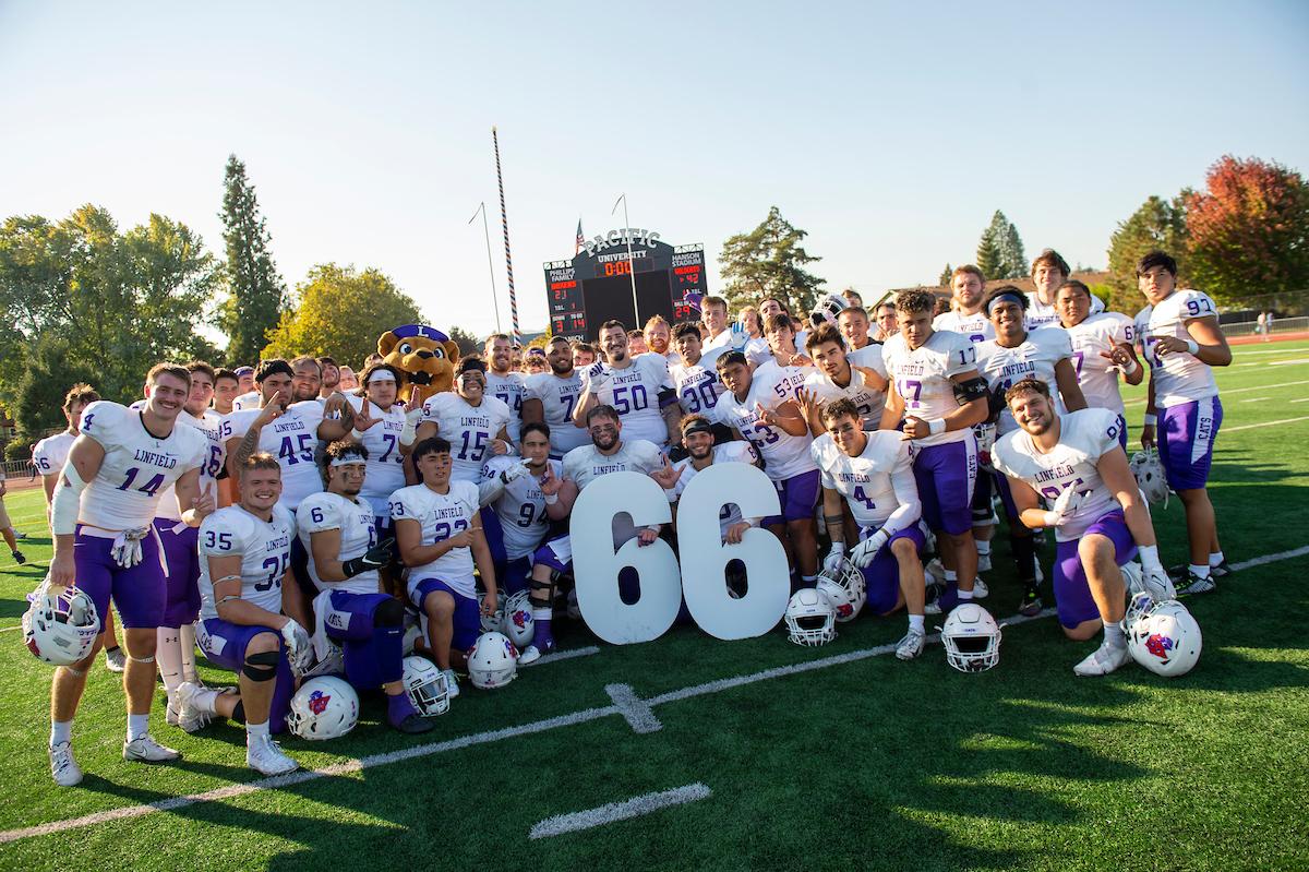 The Linfield Football team poses with the #66 after securing the sixty-sixth consecutive winning seasons in school history. Linfield defeating Pacific University 42-22 in Forest Grove, OR